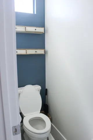 Recessed lighting, wood-finish flooring, and floating shelves with drawer storage