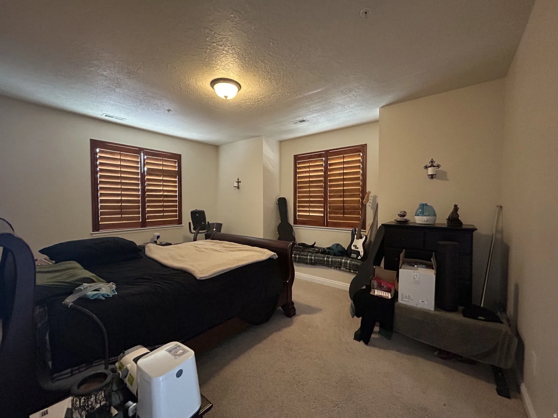 Wood-finish plantation shutters, wall-to-wall carpeting & a built-in window bench.