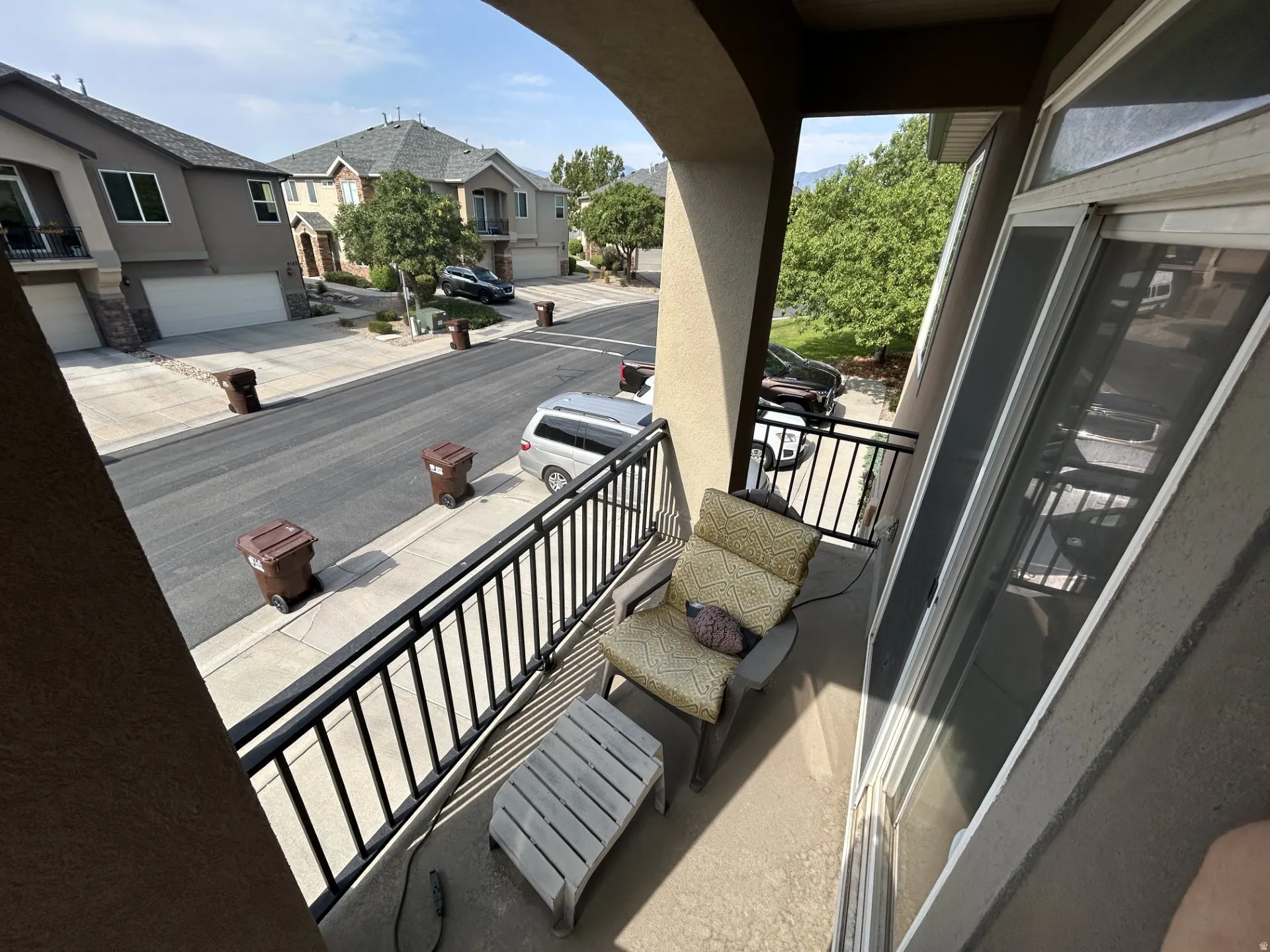 Balcony with black metal railings, concrete flooring West view.,