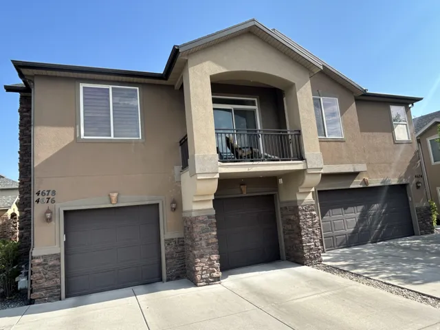 Two-level exterior with a private south facing balcony, built-in garage & stone facade accents.