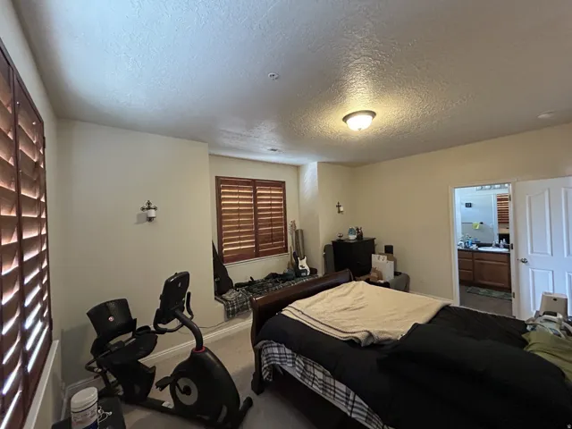 Recessed lighting, warm neutral wall tones, two windows with wood-finish shutters & a built-in window seat.