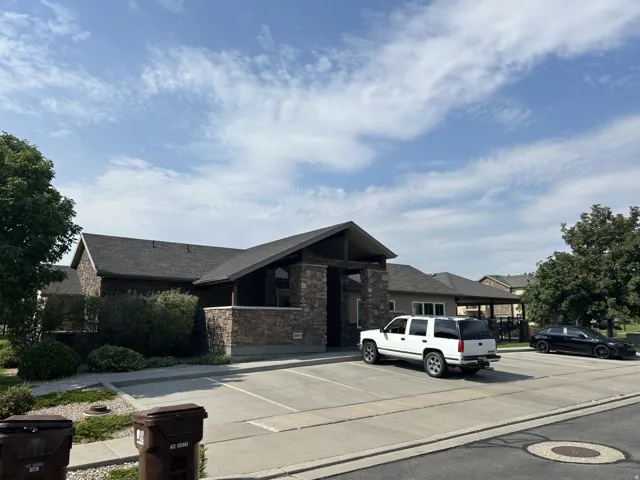 Stone veneer facade with dark shingle roof & covered entryway.