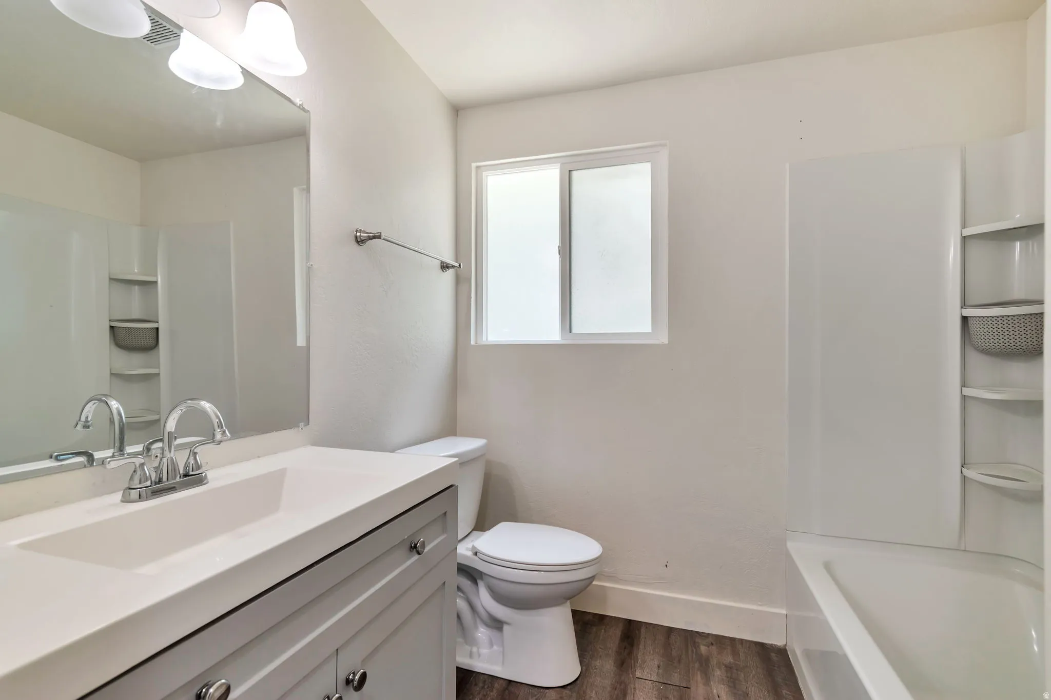 Vanity with integrated sink, chrome faucet, and gray cabinetry