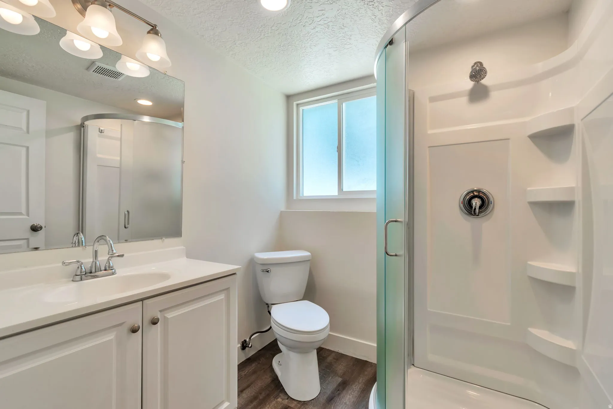 Bathroom featuring a white vanity with integrated sink, chrome faucet, and a wall-mounted mirror