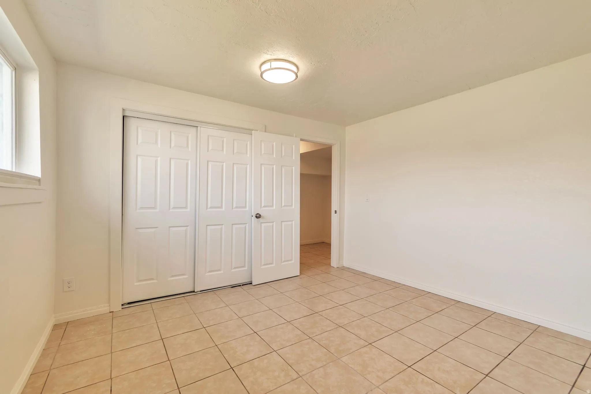 Tile flooring, white walls, and a window for natural light
