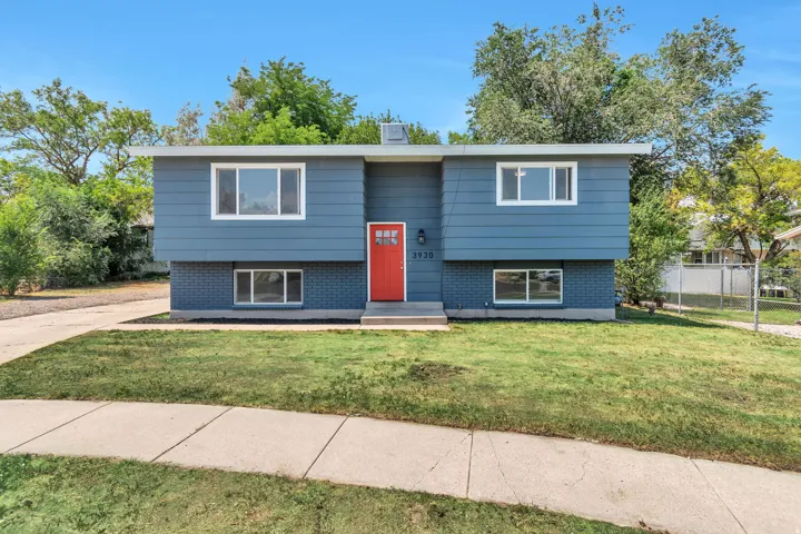 Split-level residence featuring blue siding and brick accents