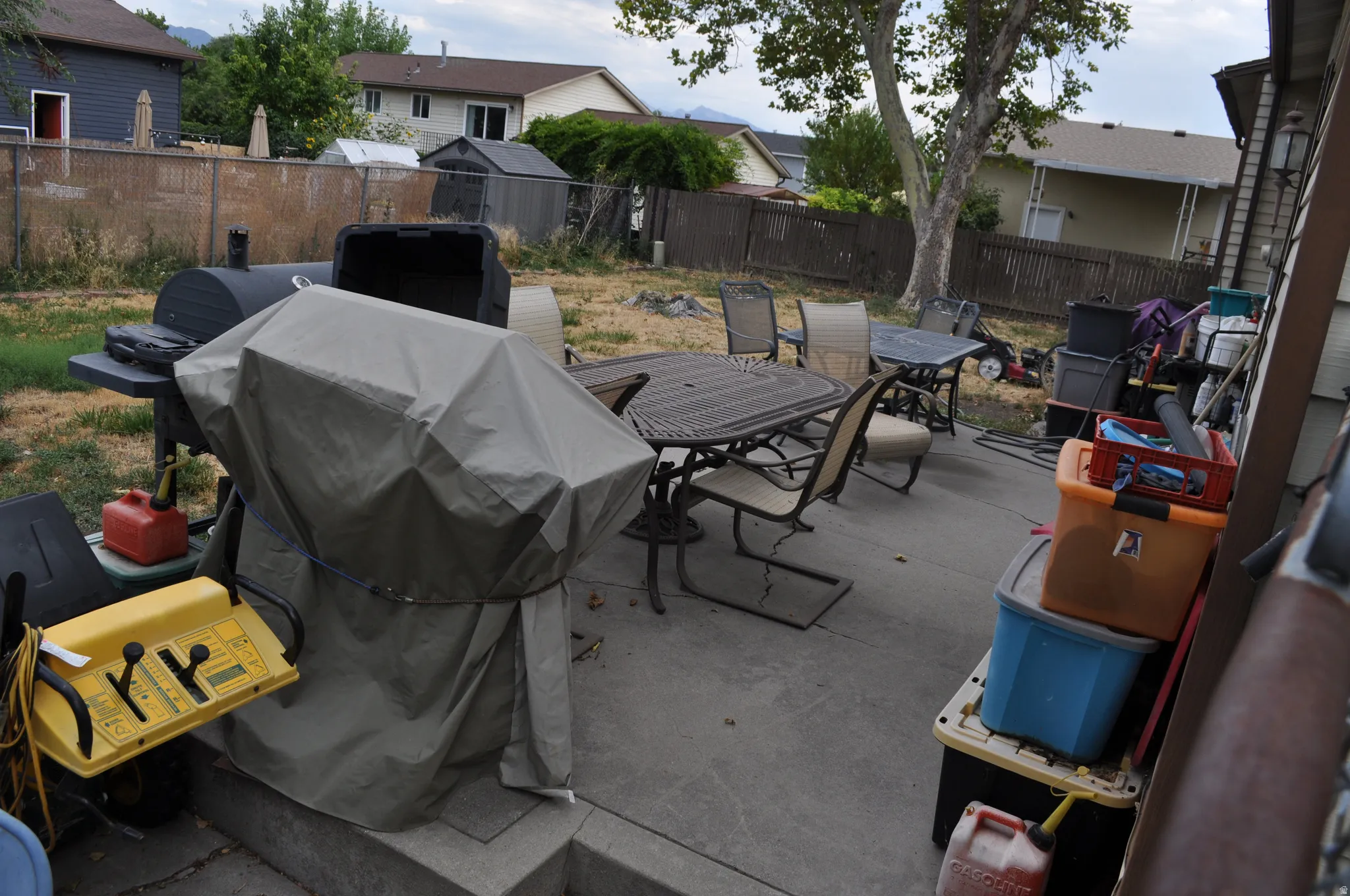 Concrete patio with a chain-link fence and a wooden fence along the perimeter