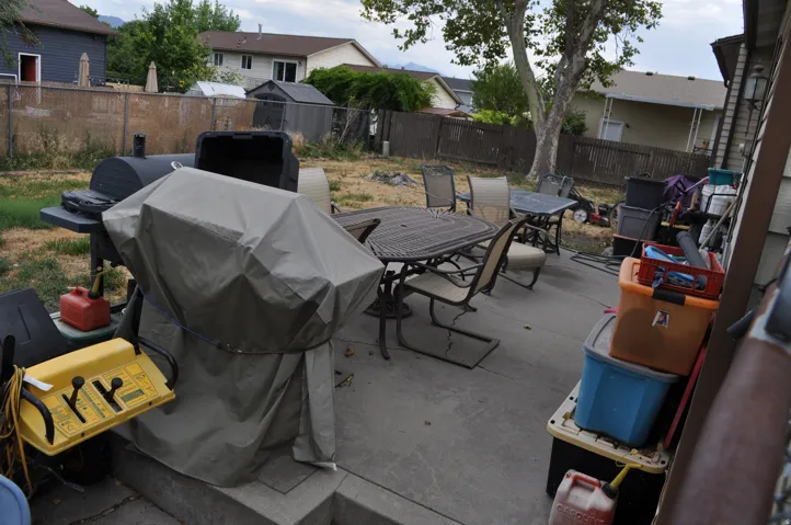 Concrete patio with a chain-link fence and a wooden fence along the perimeter