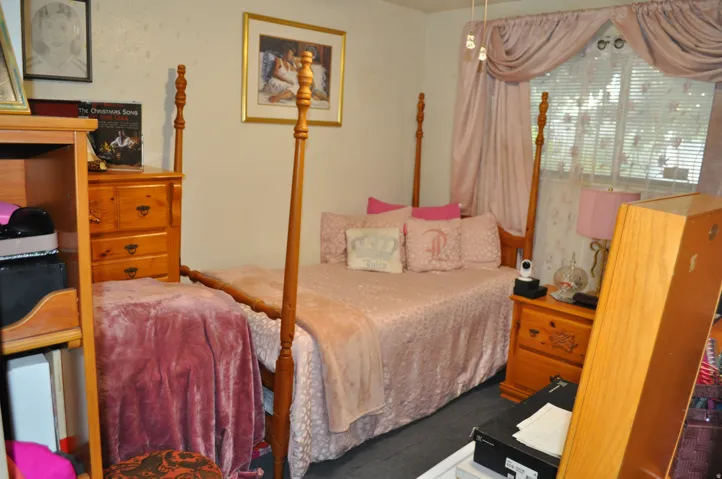 Carpeted room with a ceiling light fixture, featuring a window with blinds and valance, and light-toned walls