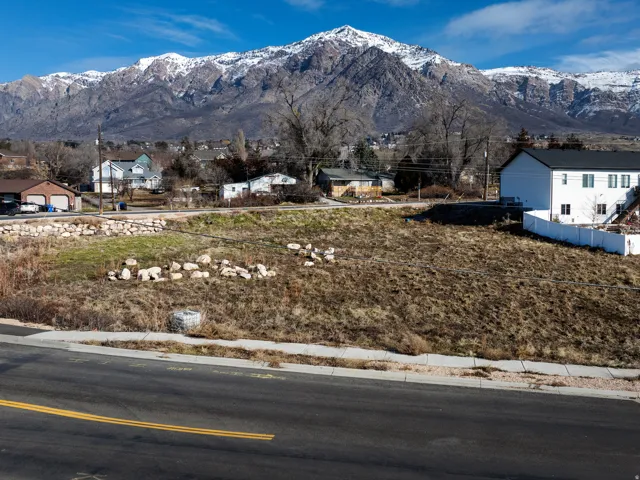Expansive land parcel with surrounding mountain scenery and established neighborhood infrastructure