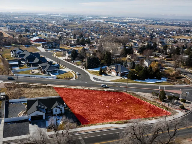 Expansive undeveloped lot featuring street frontage, a residential backdrop, and distant urban elements