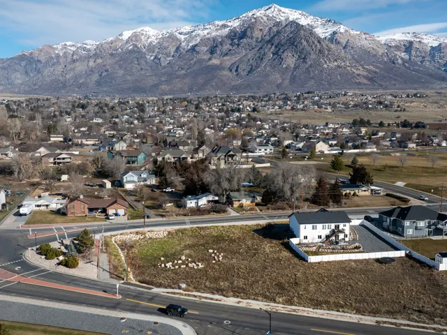 Property featuring a spacious undeveloped lot, paved road frontage, and a mountain backdrop