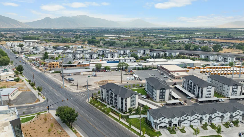 Expansive mountain backdrop with a diverse mix of residential and commercial properties, featuring multi-story apartment buildings, townhomes, and commercial structures