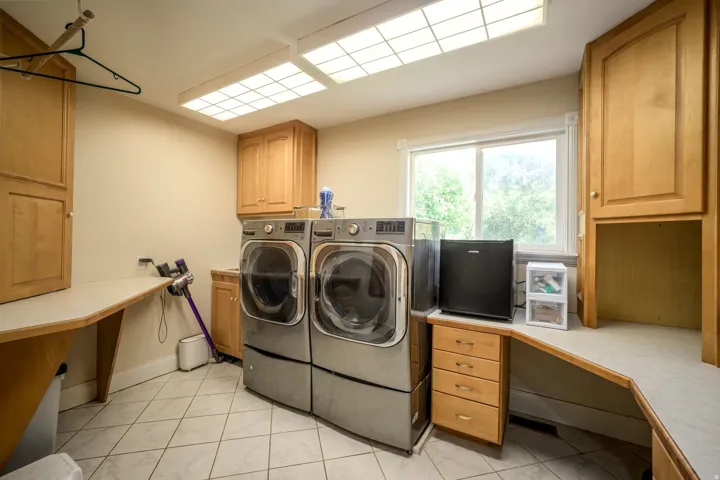 Built-in cabinetry, tile flooring, countertop workspace, and a window for natural light