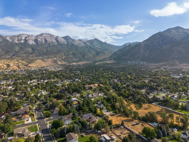 Expansive mountain backdrop with a residential community featuring mature trees and established streets