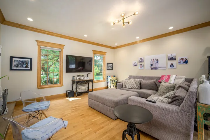 Recessed lighting, wood-finish flooring, accent crown molding, and a contemporary ceiling fixture