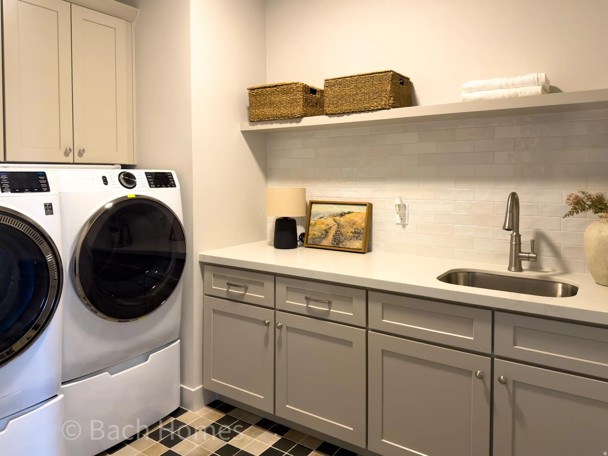 Upper cabinetry, built-in shelving, white subway tile backsplash, under-mount sink, and checkerboard floor tiles
