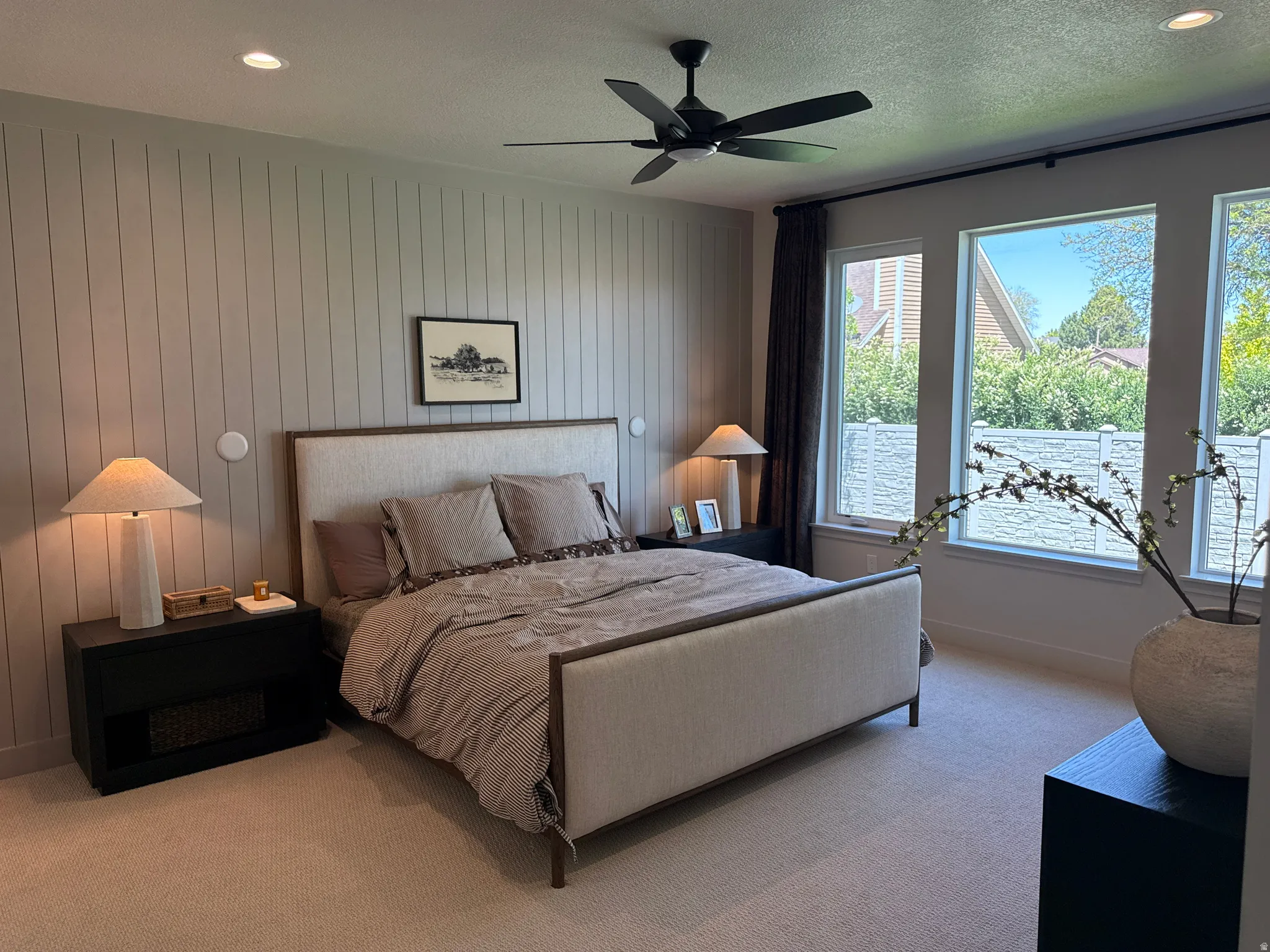 Bedroom featuring vertical panel accent wall, recessed lighting, ceiling fan, and multiple windows