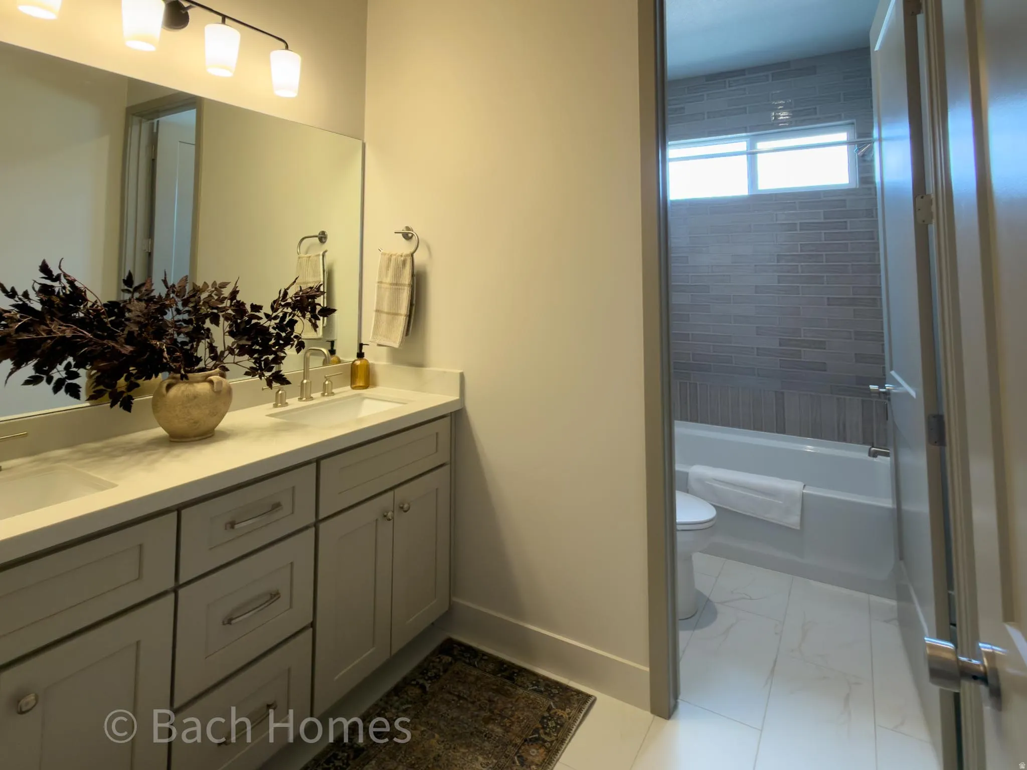 Double vanity with integrated sinks, contemporary light fixture, and a framed mirror