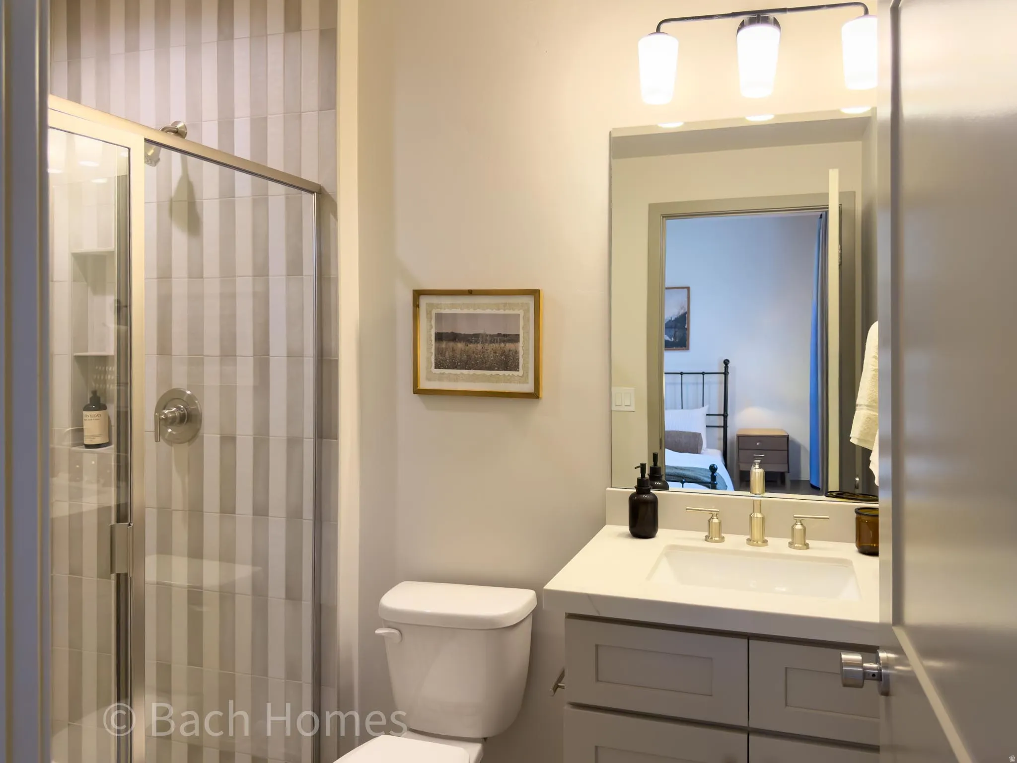 Glass-enclosed shower with vertical striped tile, chrome fixtures, and a built-in shower niche