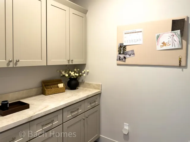 Cabinetry with panel detailing, light-toned countertop, and modern hardware
