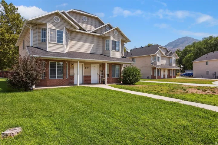 Two-story residence featuring a brick and siding exterior with a peaked roofline and gabled detailing