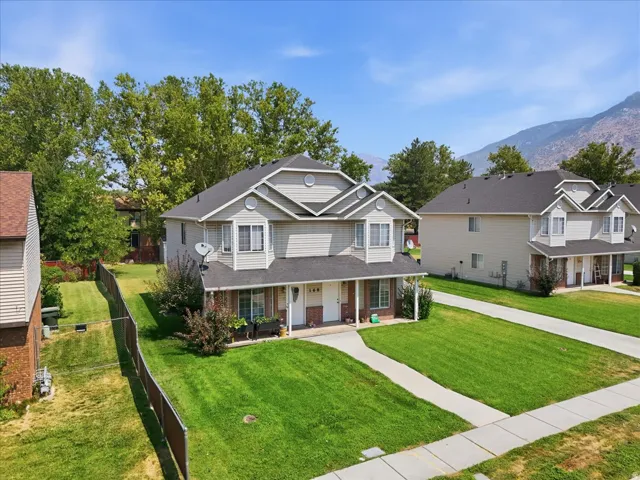 Two-story duplex with bay windows, covered entryways, and a private fenced yard