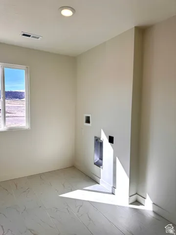 Recessed ceiling lighting, tiled flooring, window with exterior scenery, and laundry hookups