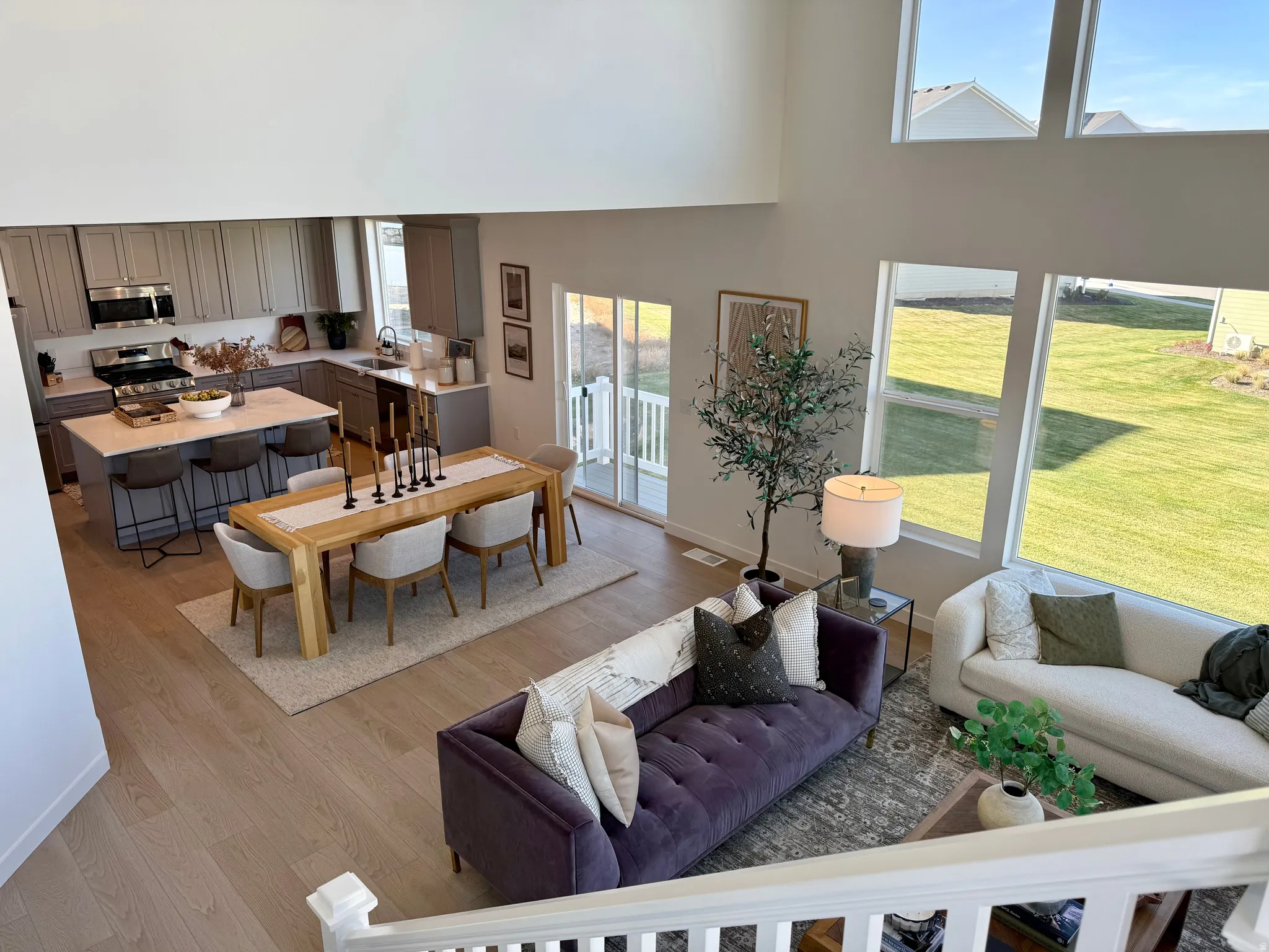 Expansive open-concept living area featuring a kitchen, dining space, and living room with wood-finish flooring