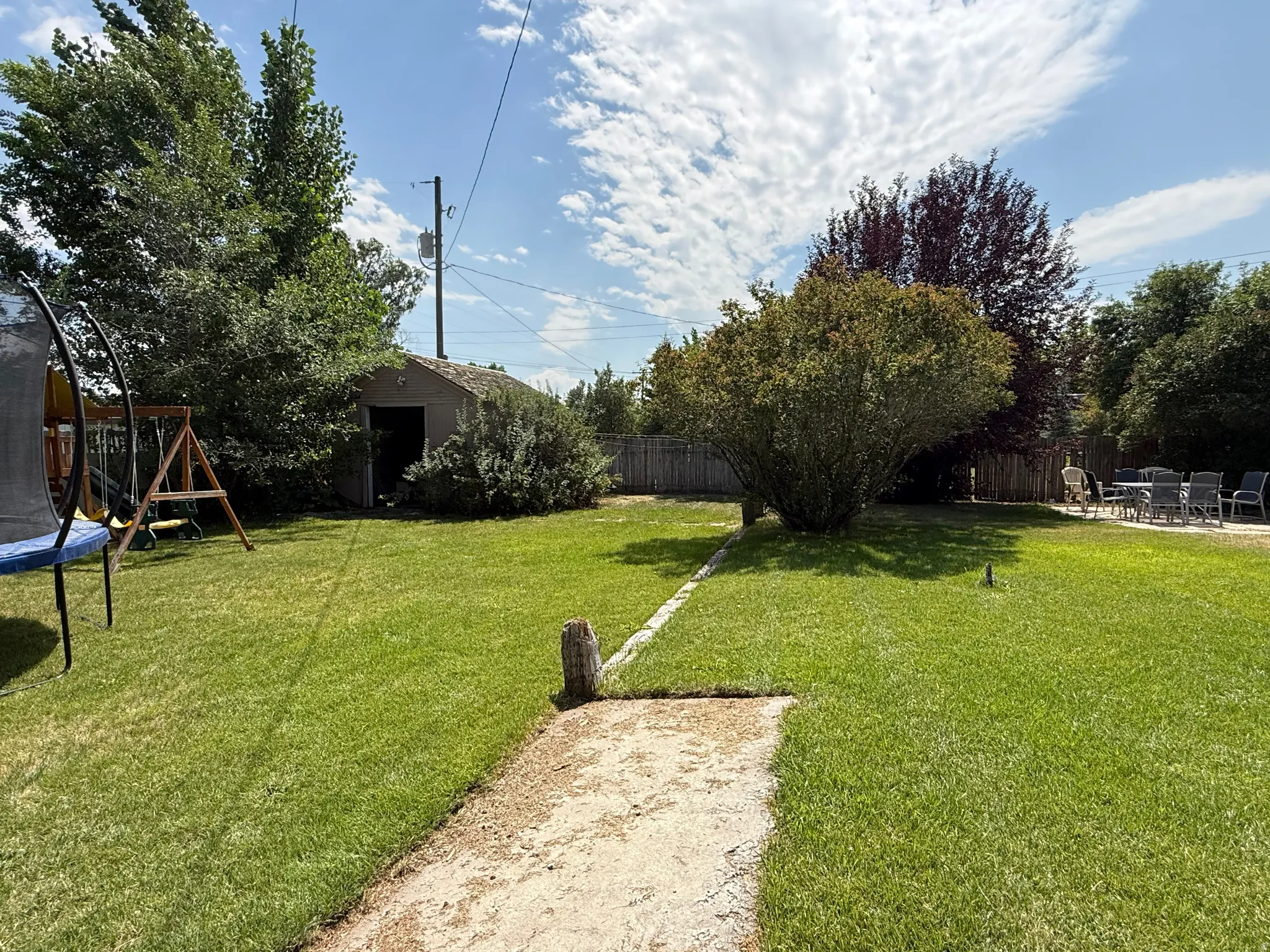 Expansive backyard with lush, manicured lawn and mature landscaping