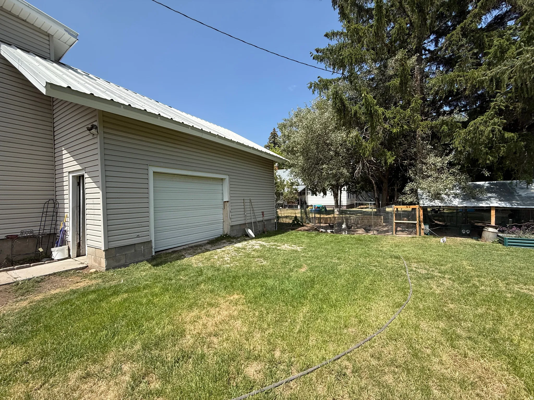 Spacious backyard with mature shade trees and manicured lawn