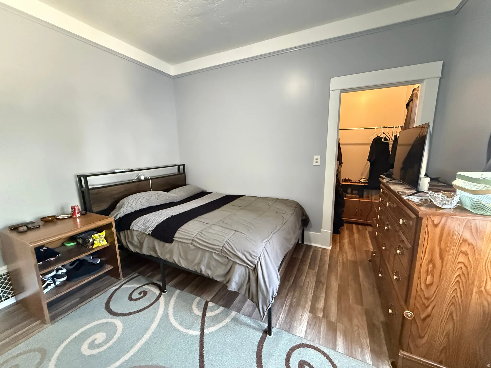 Comfortable secondary bedroom featuring wood-finish flooring, neutral wall tones, and ample natural light