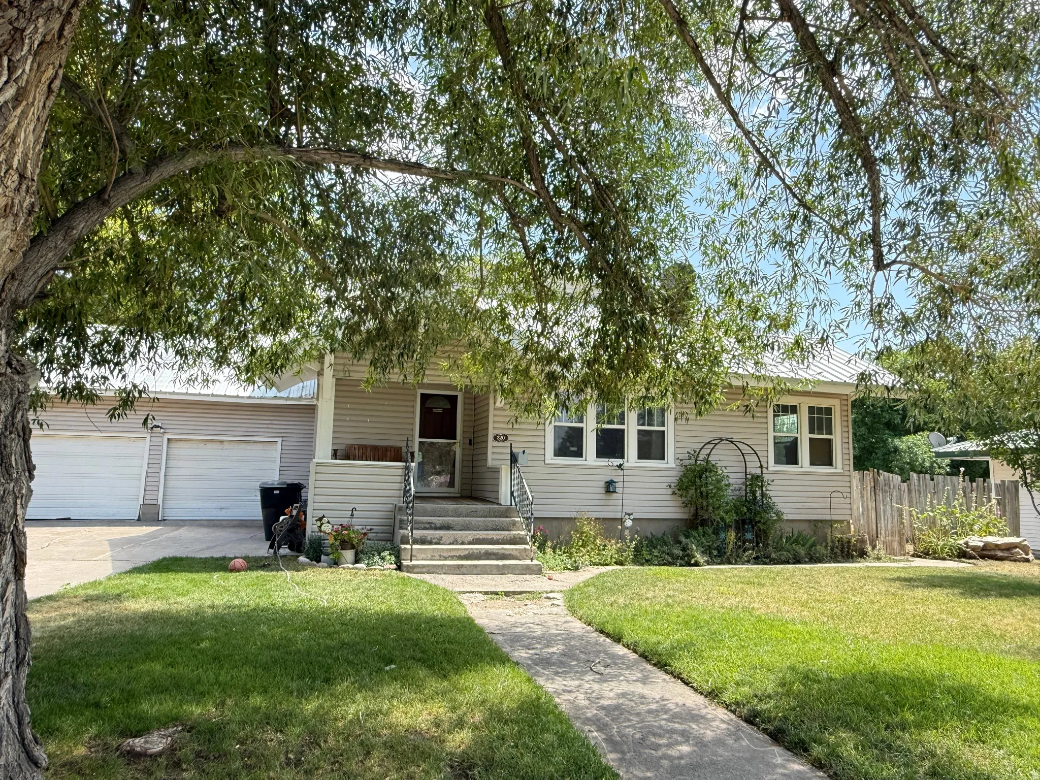 Charming single-story residence featuring a welcoming front elevation with horizontal siding, a covered entry with stepped access, and multi-pane windows