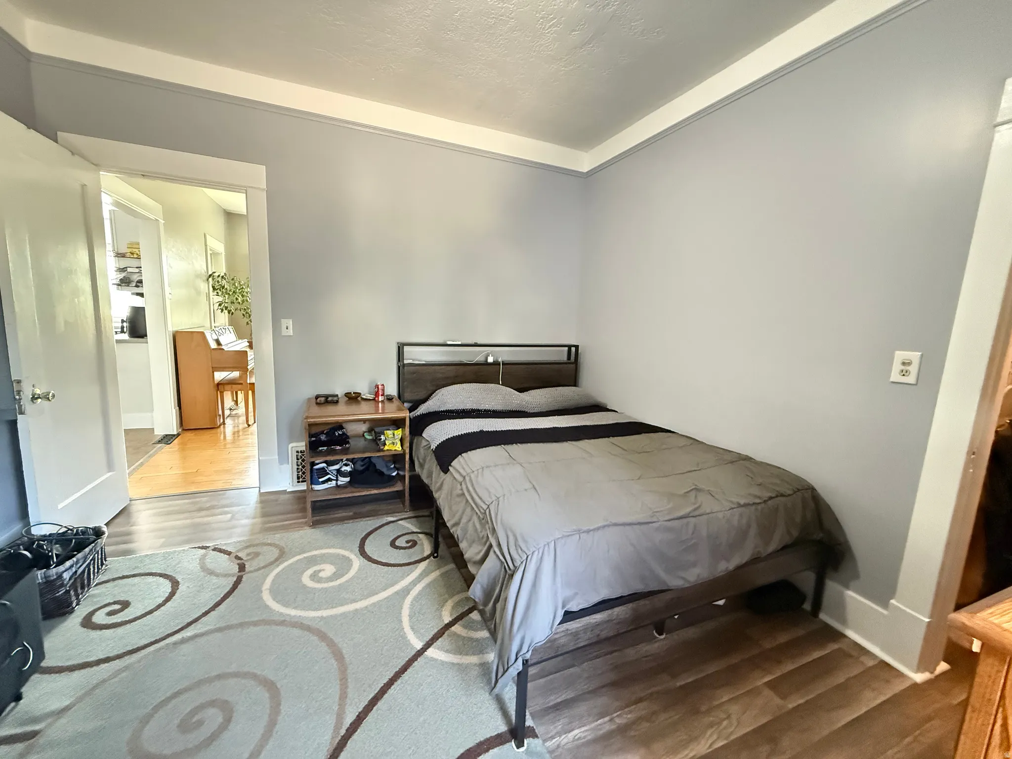 Spacious secondary bedroom featuring neutral wall finishes, wood-finish flooring, and abundant natural light from multiple windows