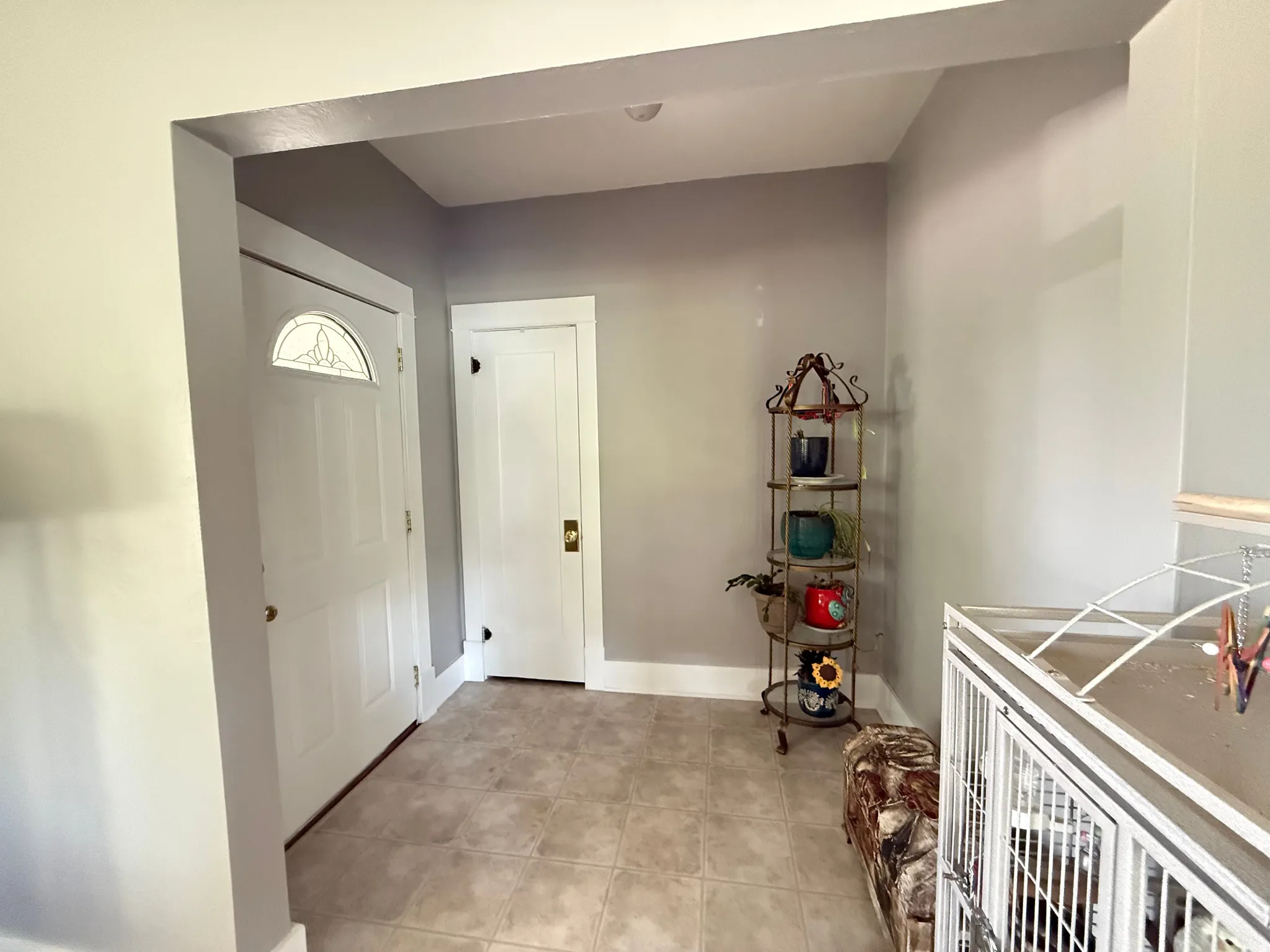 Entryway with tile flooring, white interior doors, and a decorative transom window