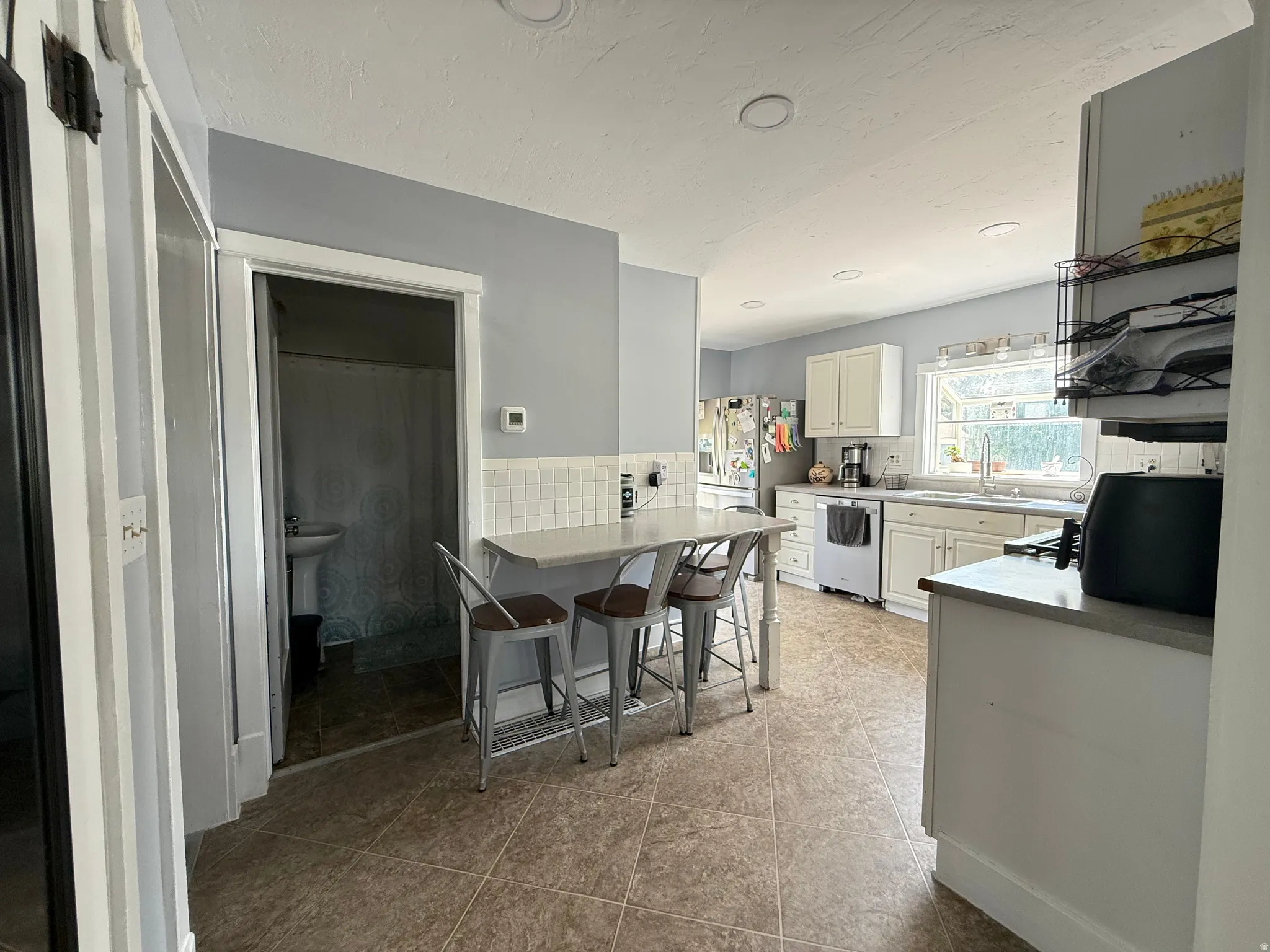 Kitchen featuring shaker-style cabinetry, recessed lighting, and a composite countertop