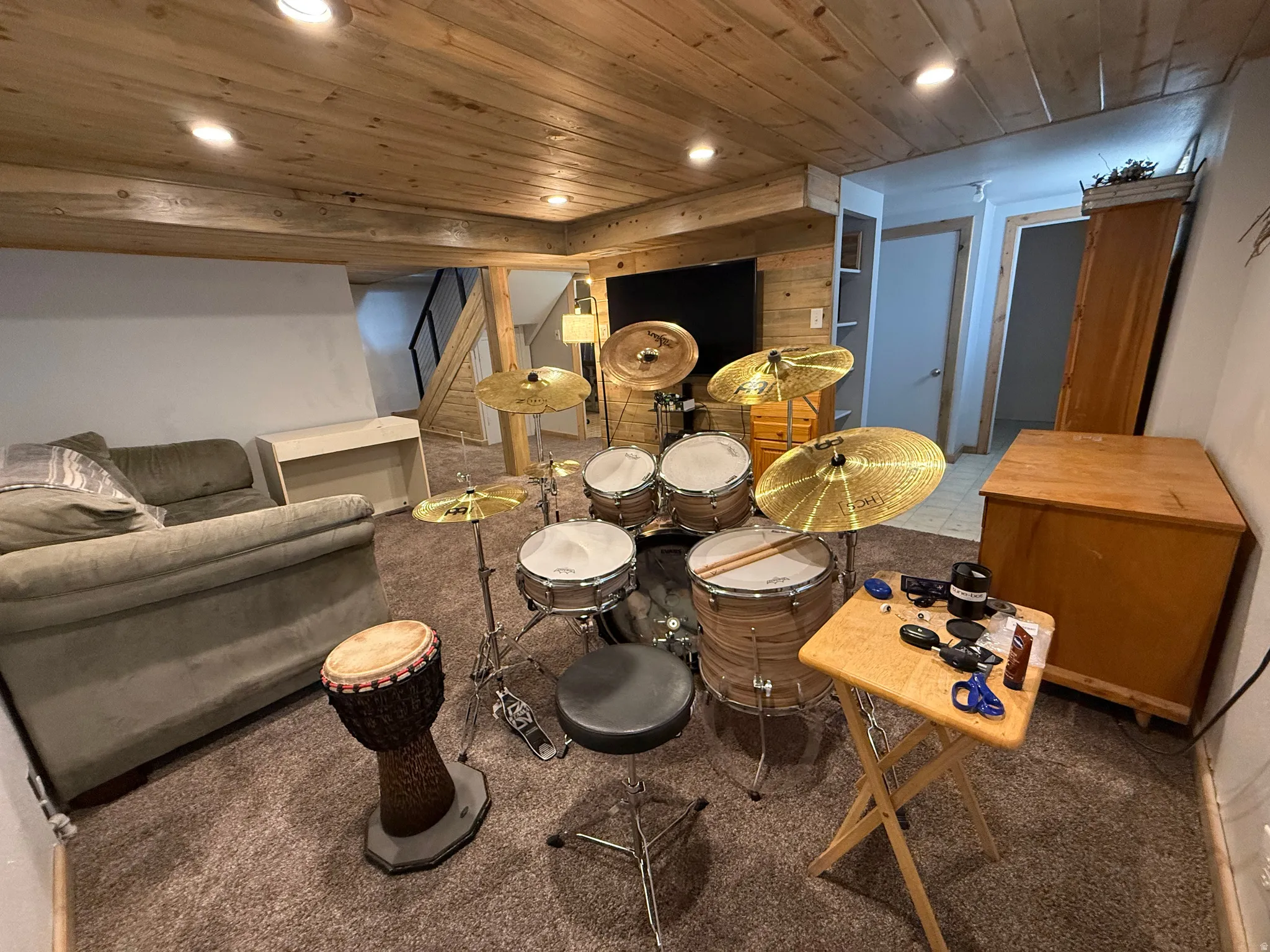 Finished basement featuring a wood-finish ceiling with recessed lighting, carpeted flooring, and built-in cabinetry