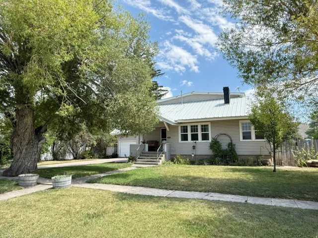 Charming farmhouse-style residence featuring a pitched metal roof, horizontal siding exterior, and covered front porch with steps