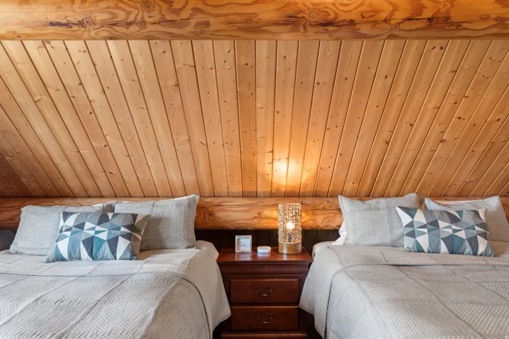 Slanted wood plank ceiling with exposed log beams