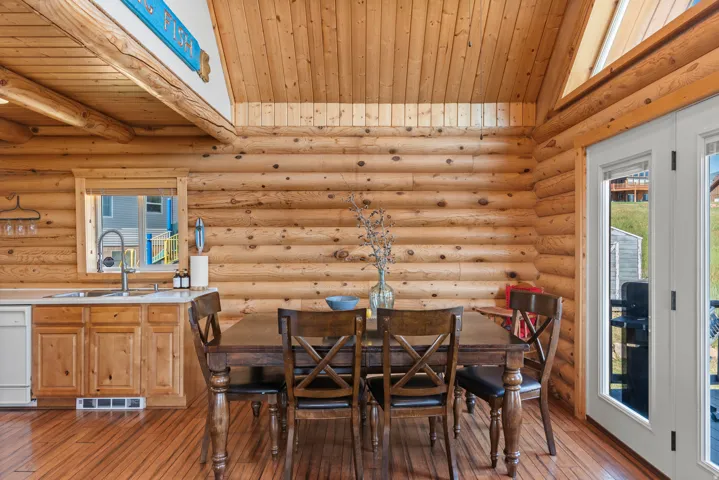 Rustic log cabin interior showcasing hand-hewn timber walls and exposed beam ceiling with skylights
