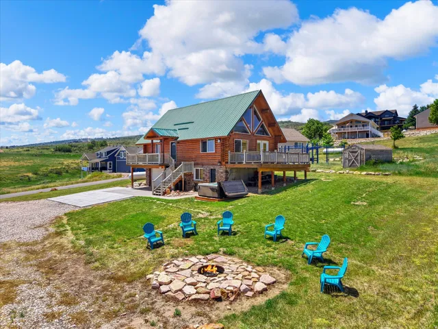 Wood-sided cabin exterior with an A-frame facade, green metal roof, and multiple wood decks