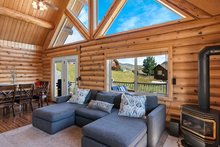 Timber log construction with soaring cathedral ceilings and expansive skylights flooding the open-concept living area with natural light