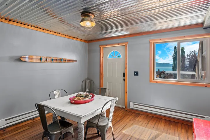 Corrugated metal ceiling, wood-finish flooring, wood trim, window with scenery, and a fluted glass door