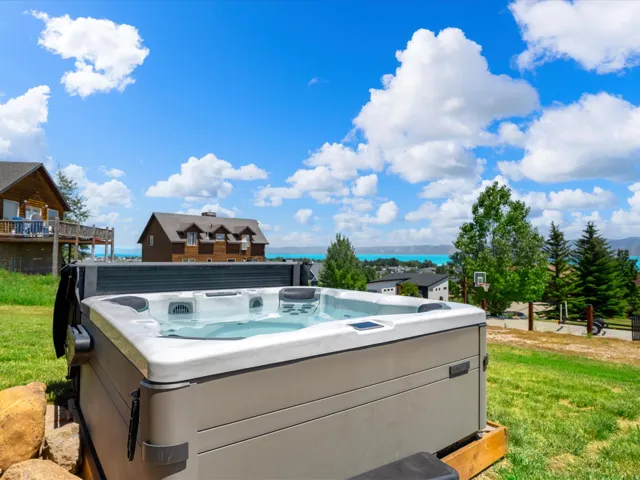 Outdoor spa with a cover, set on a grassy incline