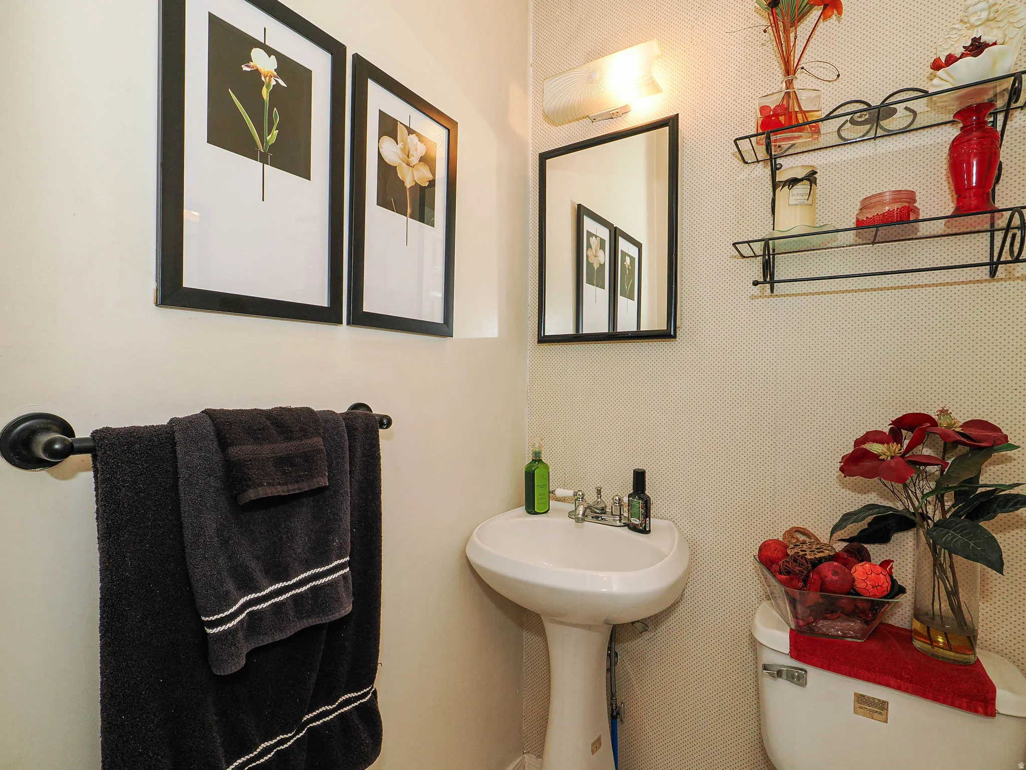 Pedestal sink with chrome fixtures and wall-mounted mirror