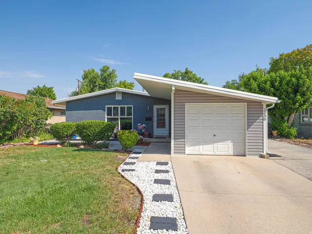 Modern single-story home featuring a clean-lined exterior with mixed siding finishes, an attached two-car garage, and a sloped roofline