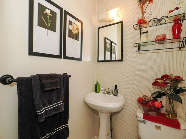 Pedestal sink with chrome fixtures and wall-mounted mirror