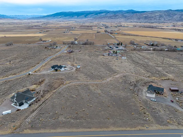Expansive acreage featuring multiple residences, a paved road, and distant mountain ranges