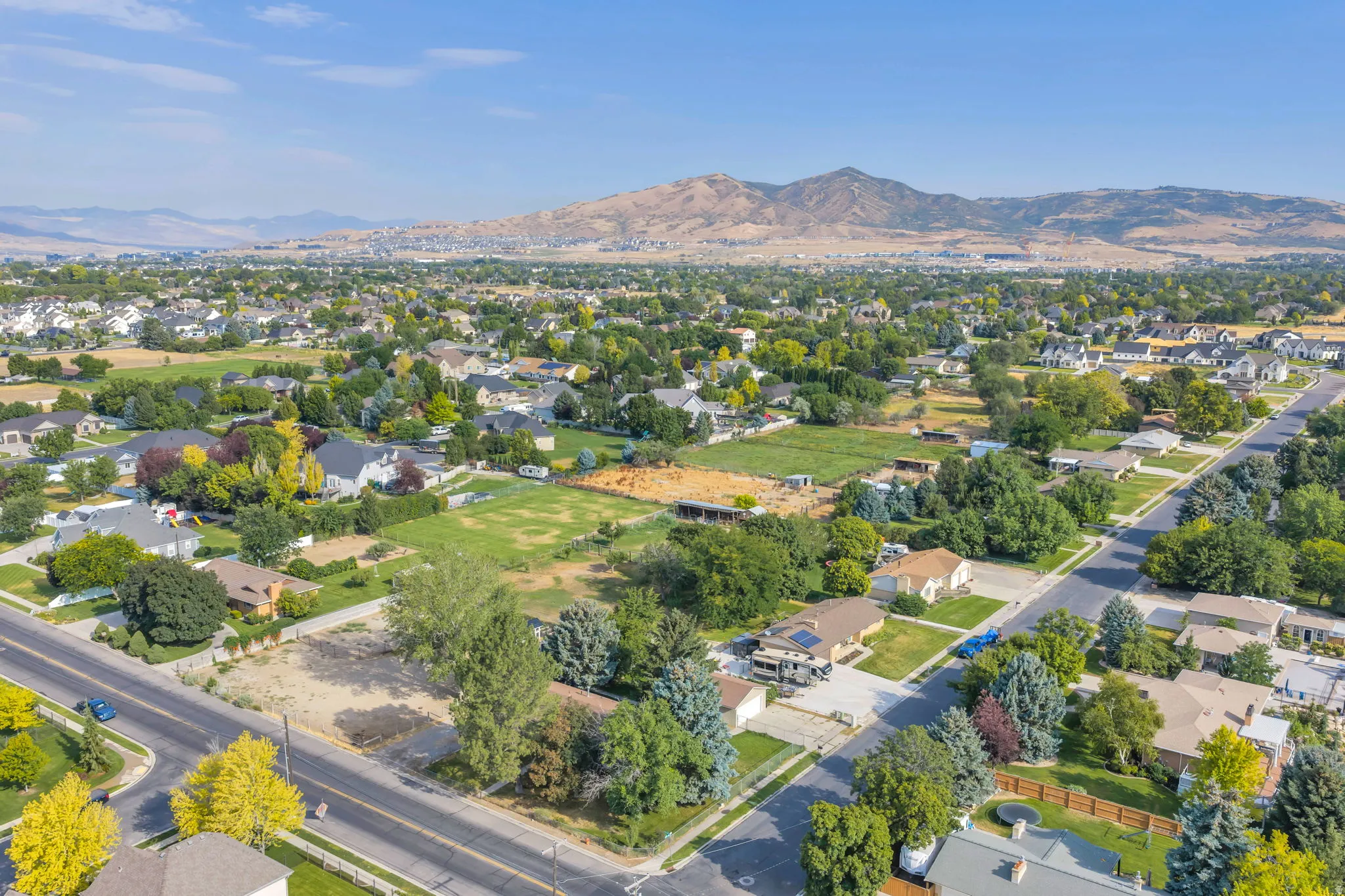 Aerial perspective showcasing a residential area with established landscaping and mountain scenery