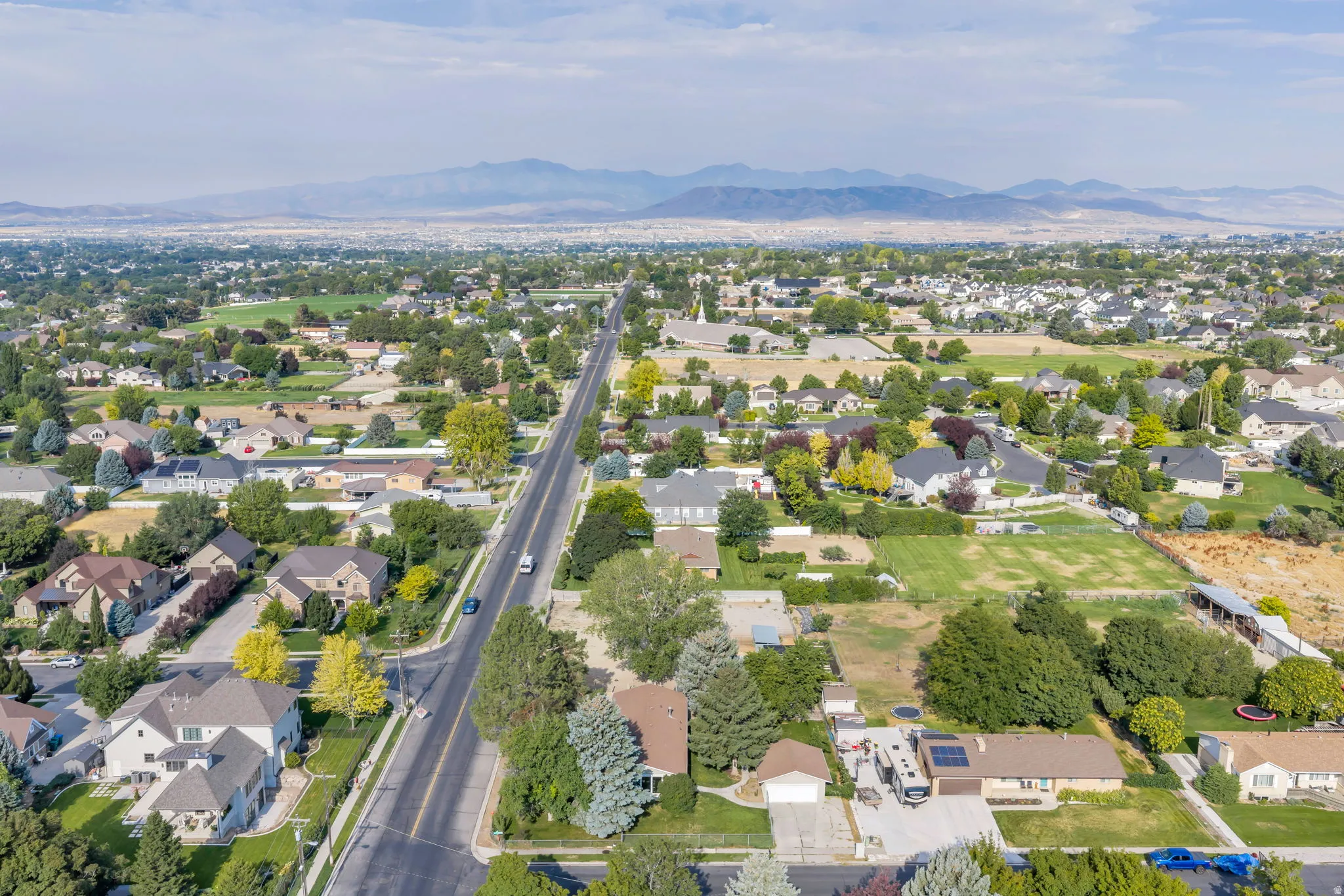 Expansive residential area featuring numerous single-family homes, mature trees, and a paved road network